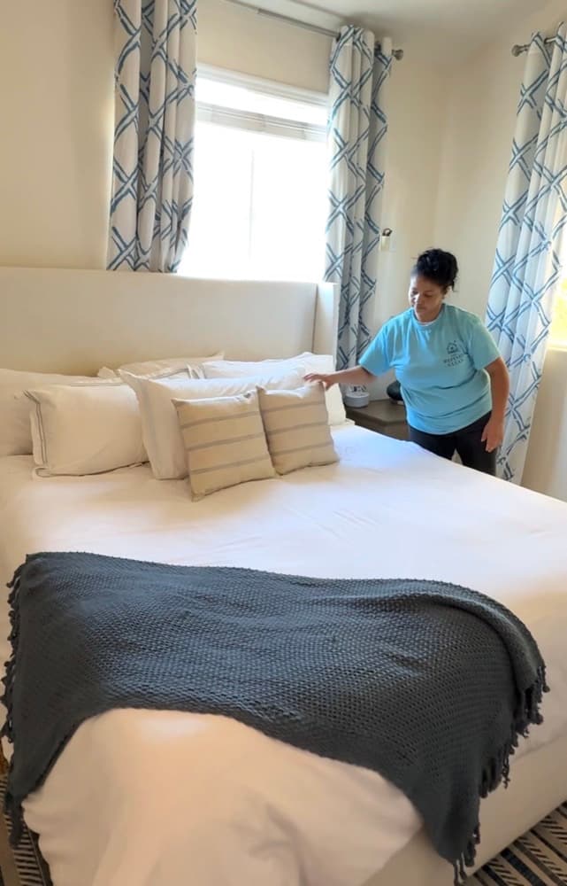 A Refined Clean team member making a bed